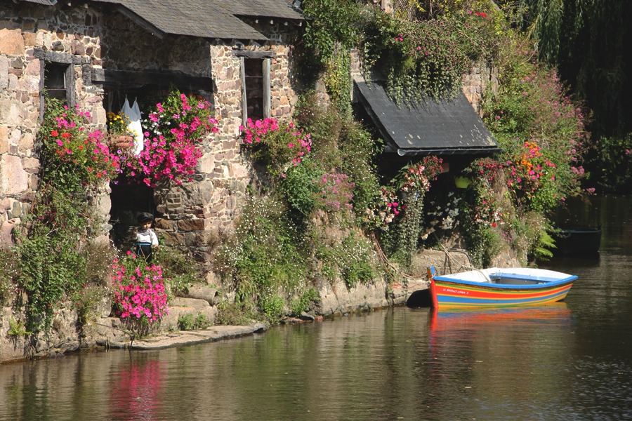 Ein buntes Holzboot liegt vor einem alten Waschhaus am Ufer des Trieux in Pontrieux.