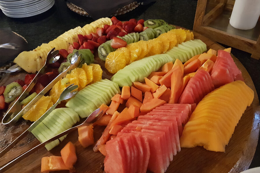 Große Obstplatte mit Stücken von Melone, Papaya, Orange, Kiwi, Erdbeeren und Ananas.