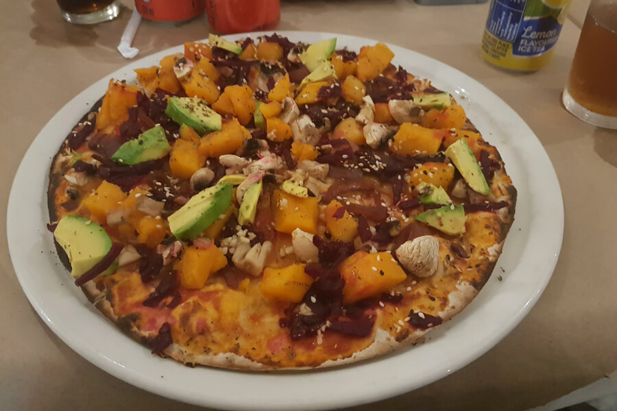 Vegane Pizza mit Kürbis, Avocado, Roter Beete und Pilzen.