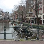 Fahrräder sind am Geländer an einer Gracht angeschlossen.