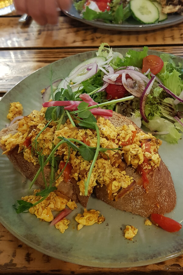 Veganes Scrambled Tofu auf Brot mit Salat im Preps Café in Maastricht.