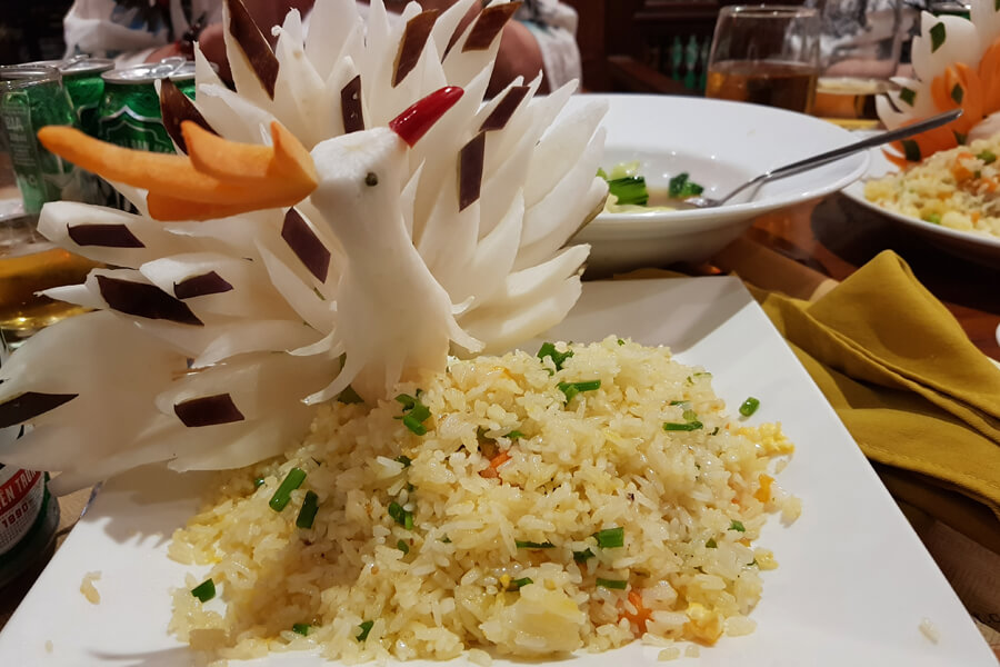 Veganer gebratener Reis verziert mit einem geschnitzen Vogel.