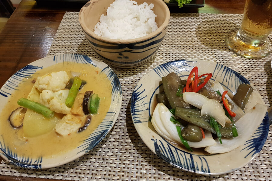 Drei Schälchen, links mit Gemüsecurry, in der Mitte mit Reis, rechts mit gekochter Aubergine.