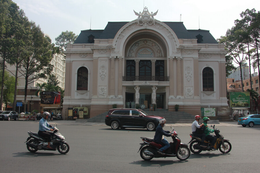 Mopeds fahren auf der Straße vor der Oper von Saigon.