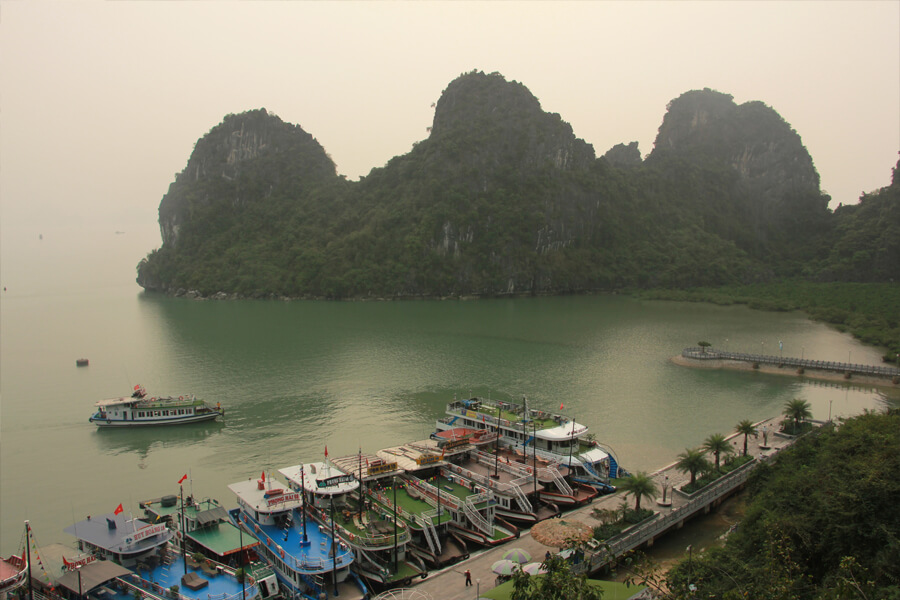 Touristenboote liegen am Steg in der Halong Bucht.