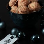 Rezept: vegane Kokosmakronen Vegane Kokosmakronen in einer Schale, im Hintergrund hellblaue Weihnachtsbaumkugeln.
