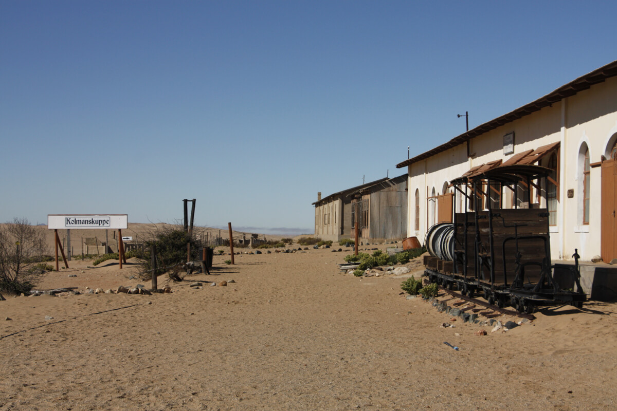 Verlassene Häuser und altes Stadtschild in Kolmanskop
