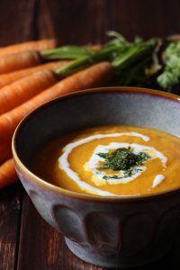 Eine Schale Karottencremesuppe mit Pesto Topping