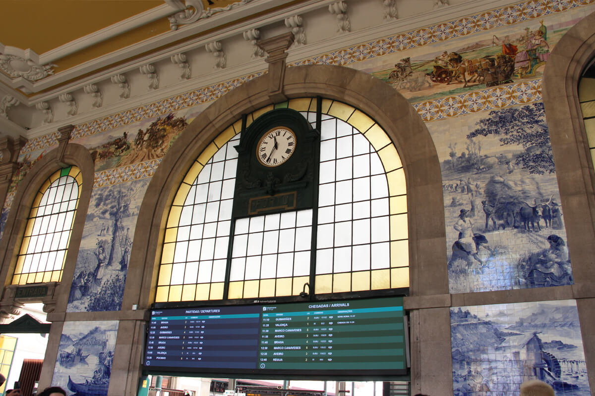Anzeigetafel zwischen blau-weißen Azulejos im Bahnhof Sao Bento.