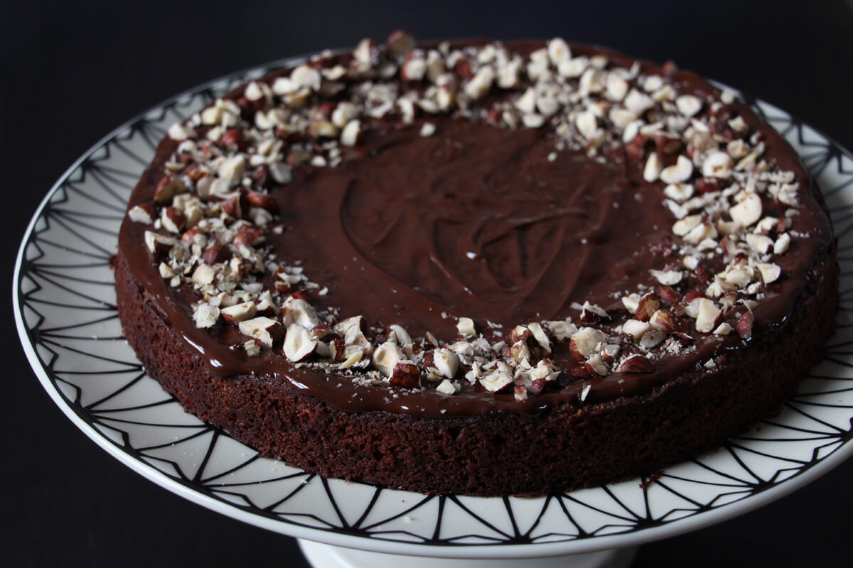 veganer Nougatkuchen mit Schokoglasur und gehackten Nüssen