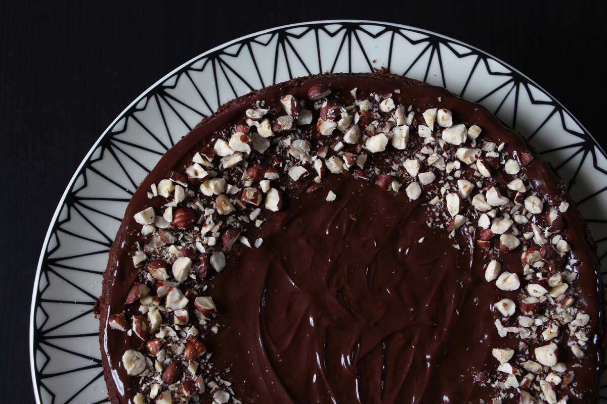 veganer Nougatkuchen mit Schokoglasur und gehackten Nüssen