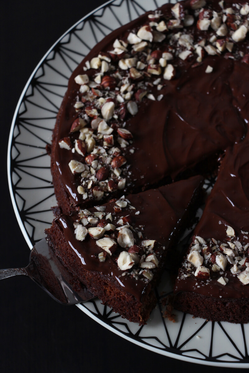 ein Stück veganer Nougatkuchen wird mit dem Tortenheber aus dem ganzen Kuchen genommen