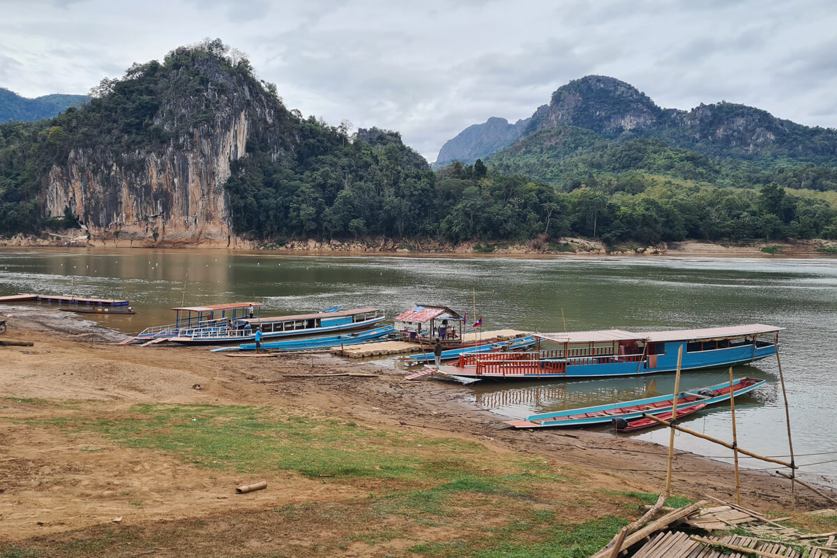 Mit den Longtailbooten kannst du über den Fluss zu den Höhlen übersetzen