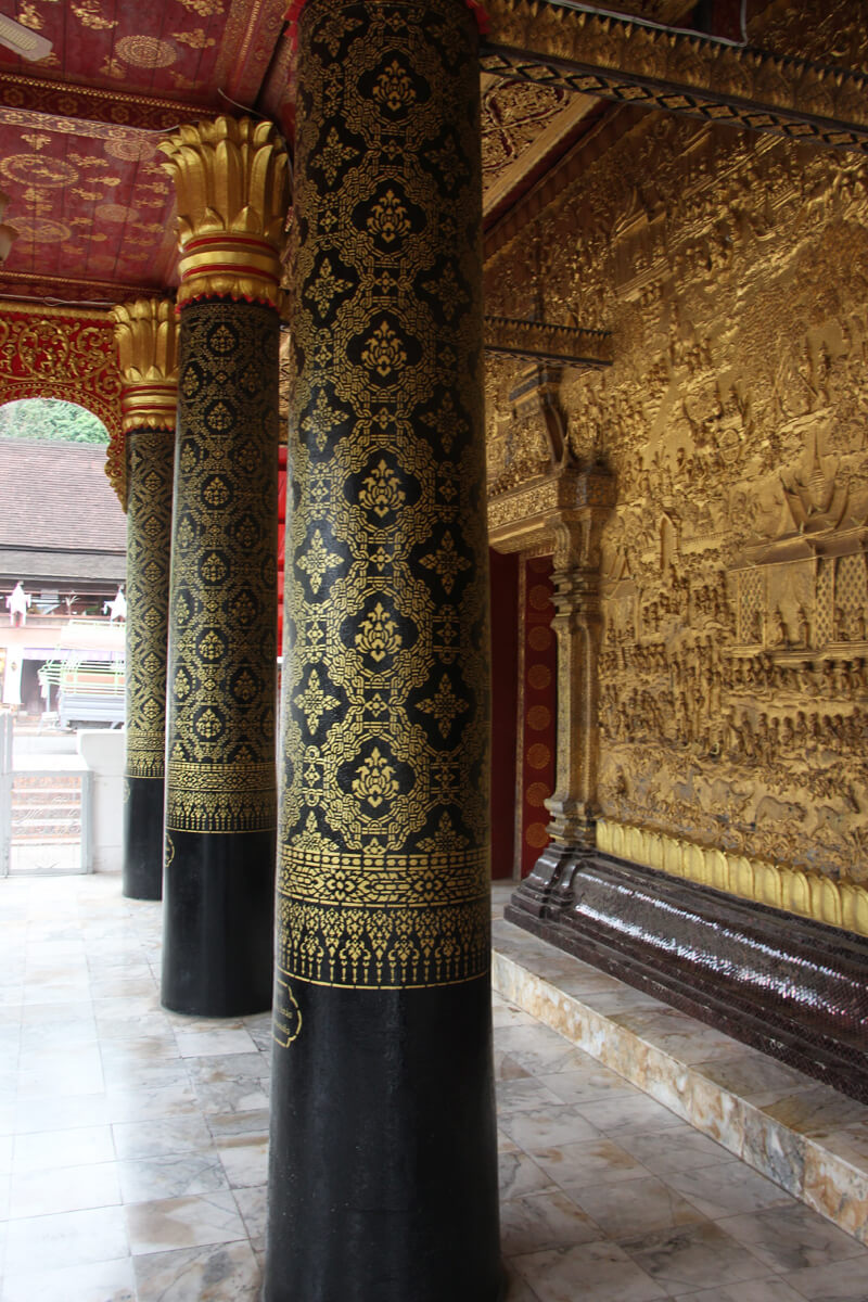 Typische Säulen und ein goldenes Relief im Tempel