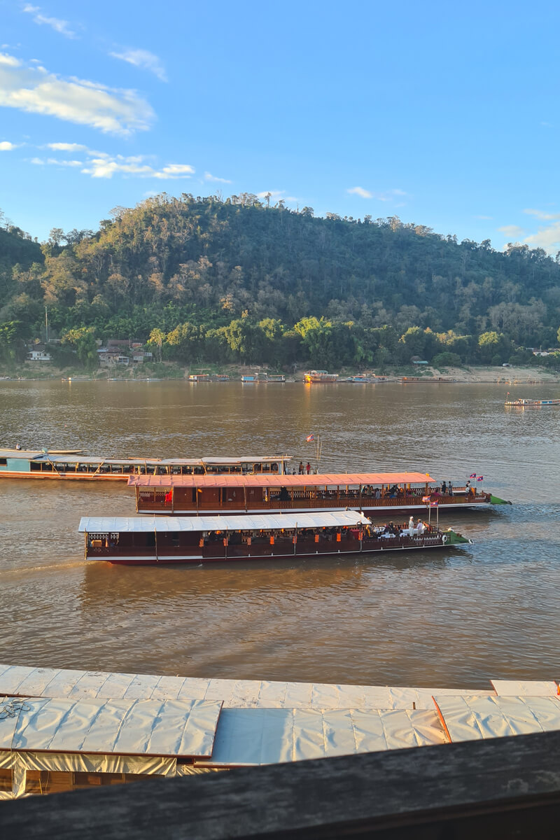Longtailboote kreuzen auf dem Mekong bei Luang Prabang