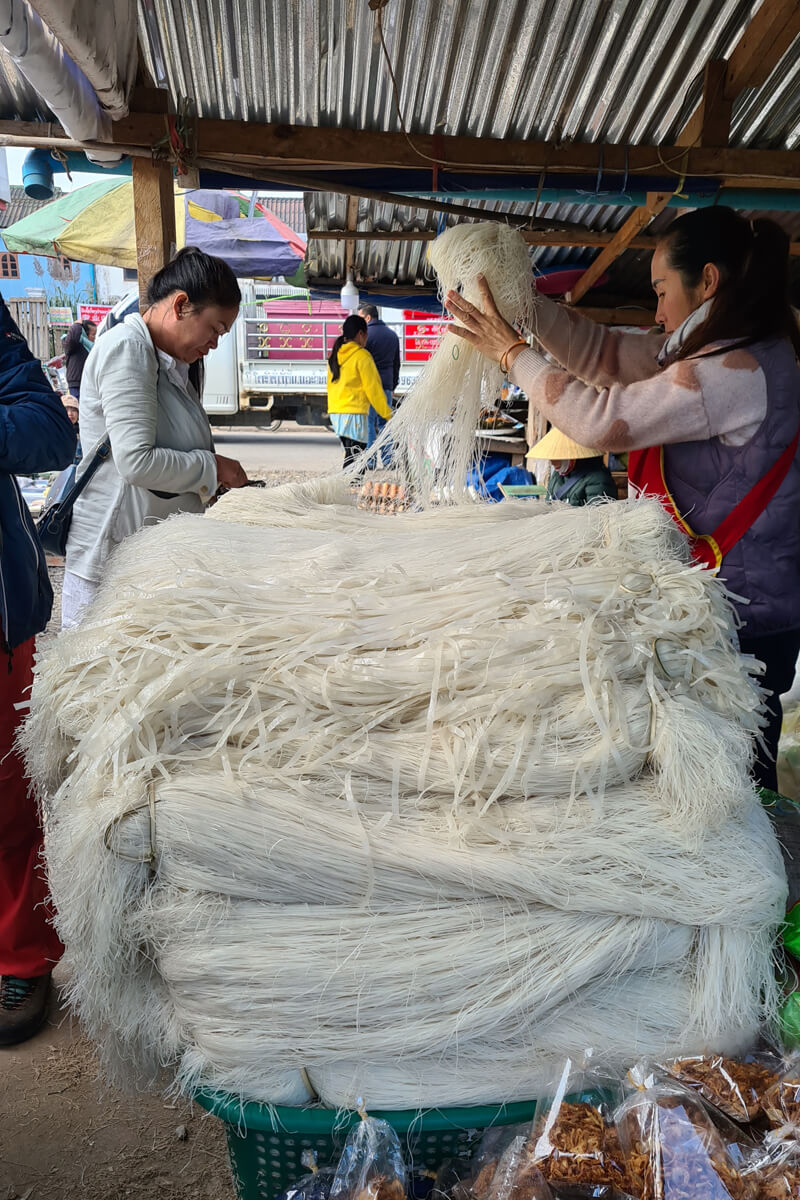 Ein riesiger Berg frischer Reisnudeln wird auf dem Markt zum Kauf angeboten.