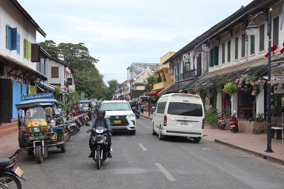 Tuktuks, Mopeds und Kleinbusse fahren über die Sisavanvong Road