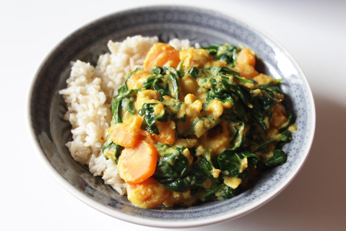 Eine Bowl mit Süßkartoffel-Spinat-Curry und Reis