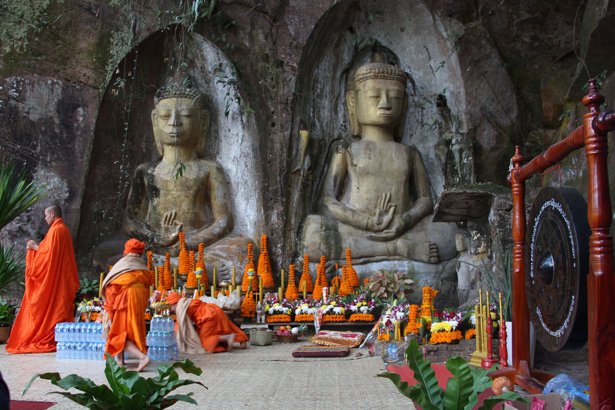 Ein buddhistischer Tempel mit Figuren und Opfergaben in Laos