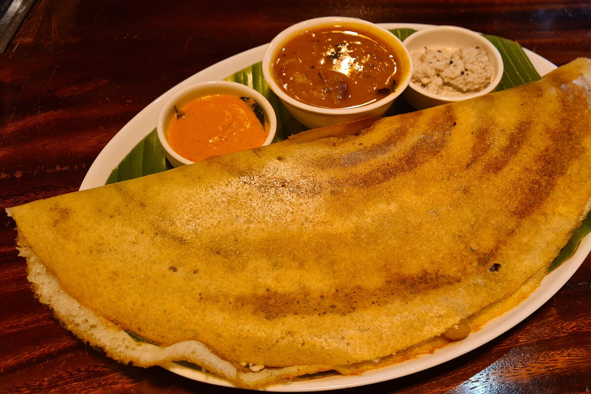 Masala Dosa, ein herzhaft gefüllter Pfannkuchen mit verschiedenen Dips