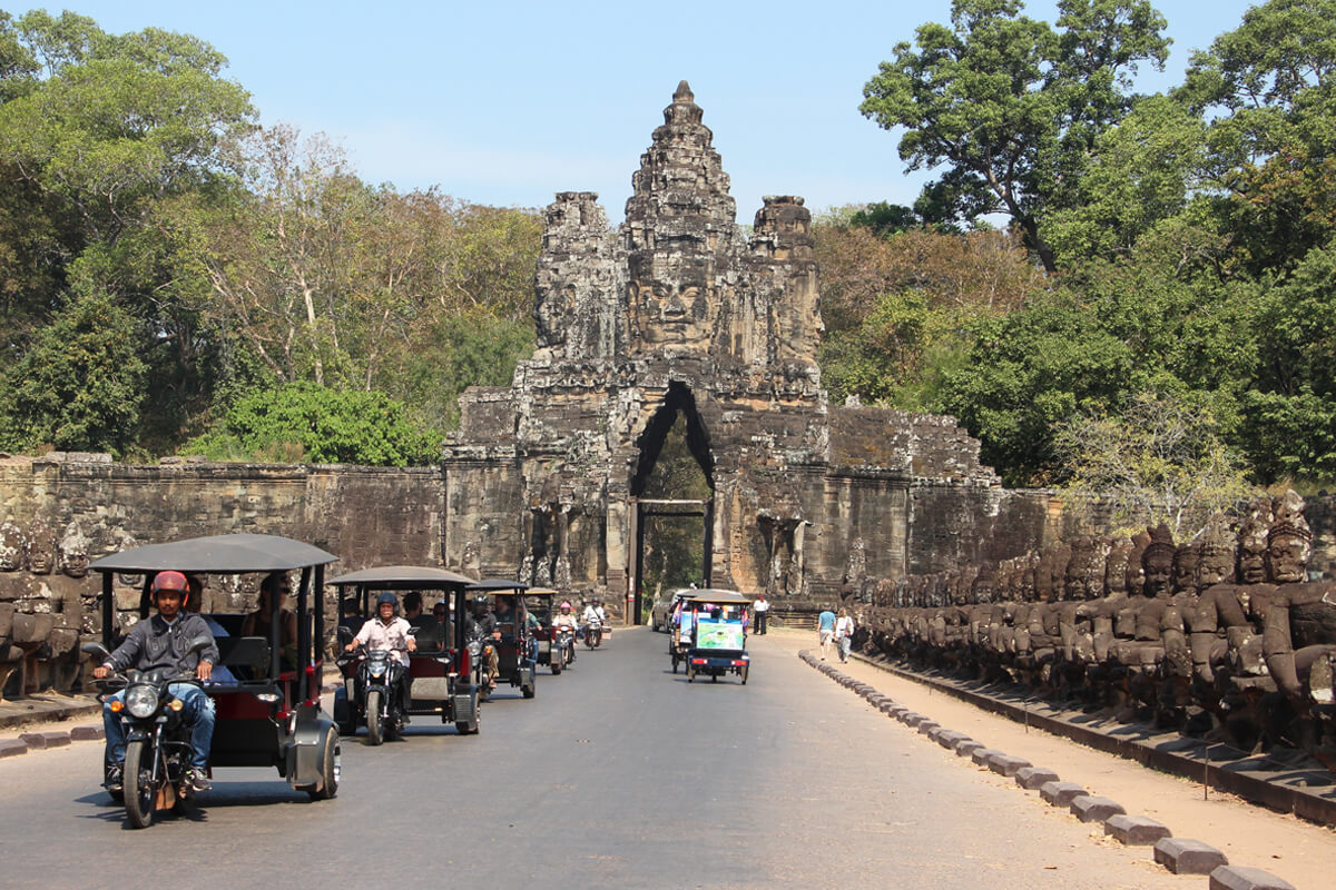 Tuktuks fahren durch ein Tor des Angkor Thom Tempels