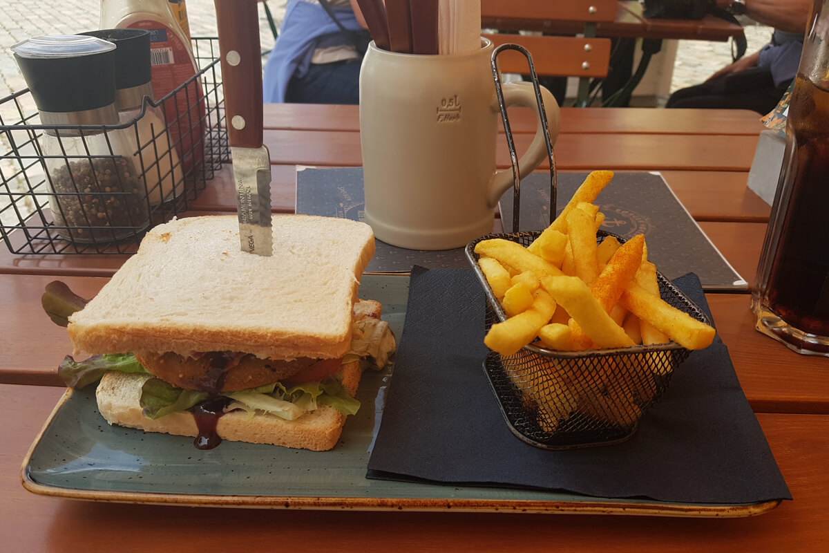 veganer Burger zwischen Sandwichscheiben und Pommes