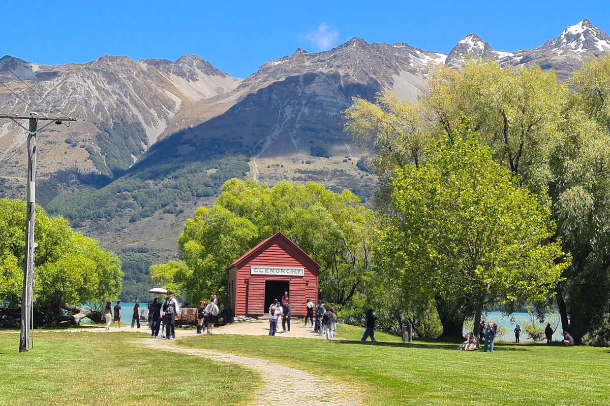 Kleine rote Holzhütte zwischen hohen Bergen in Glenorchy
