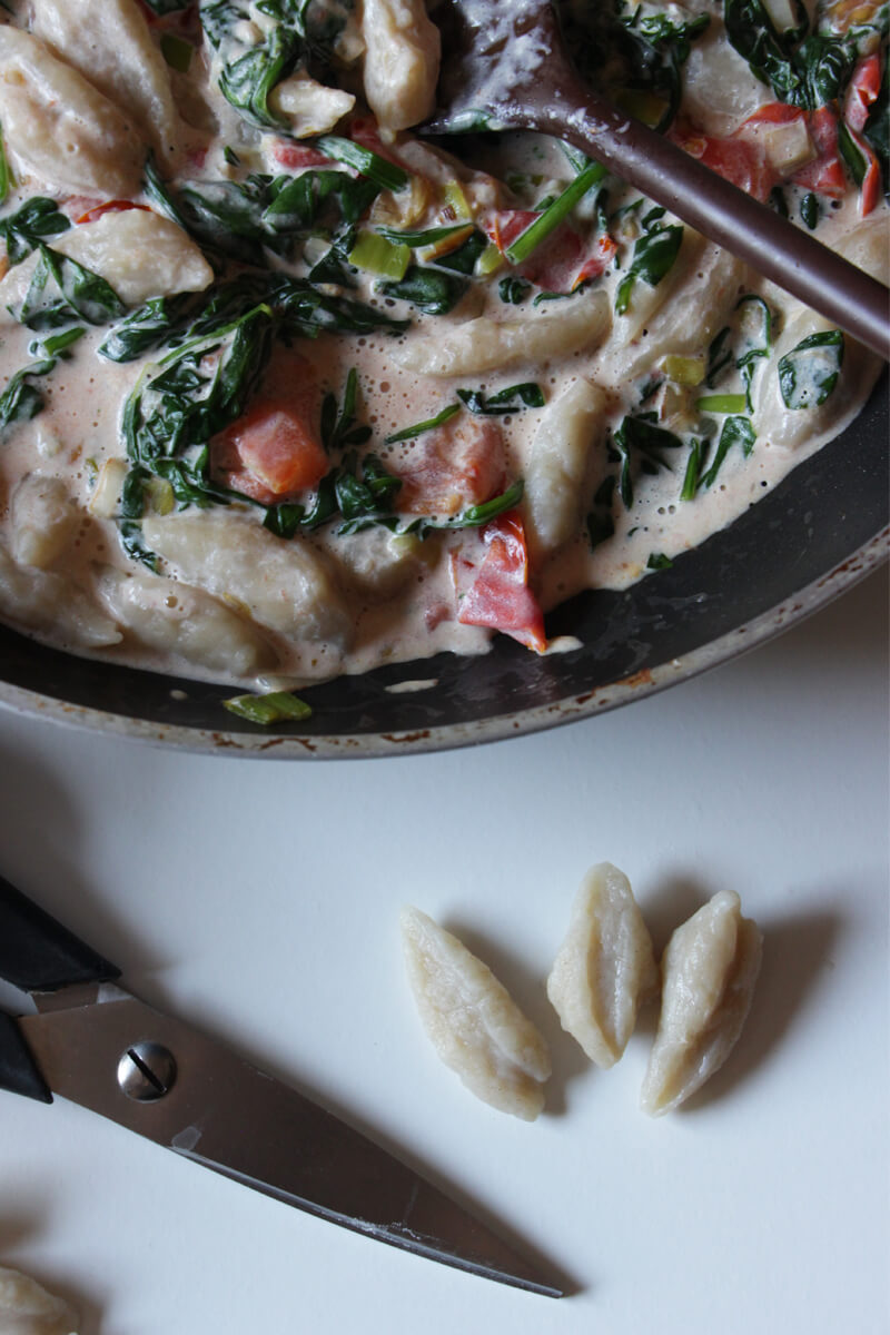 vegane Scherenpasta mit Soße in einer Pfanne, daneben eine Küchenschere