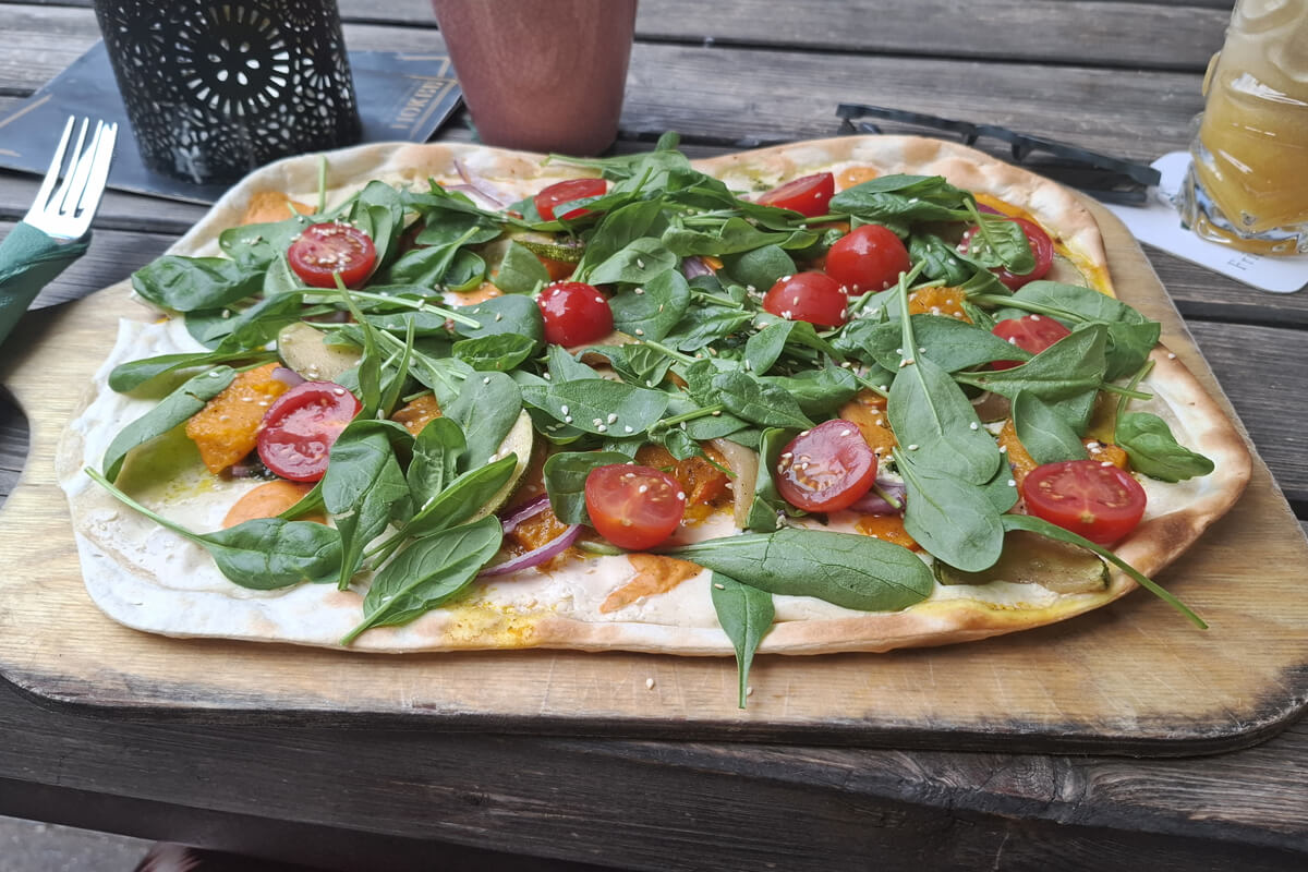 Dicht belegter Flammkuchen in der Mokel Bar
