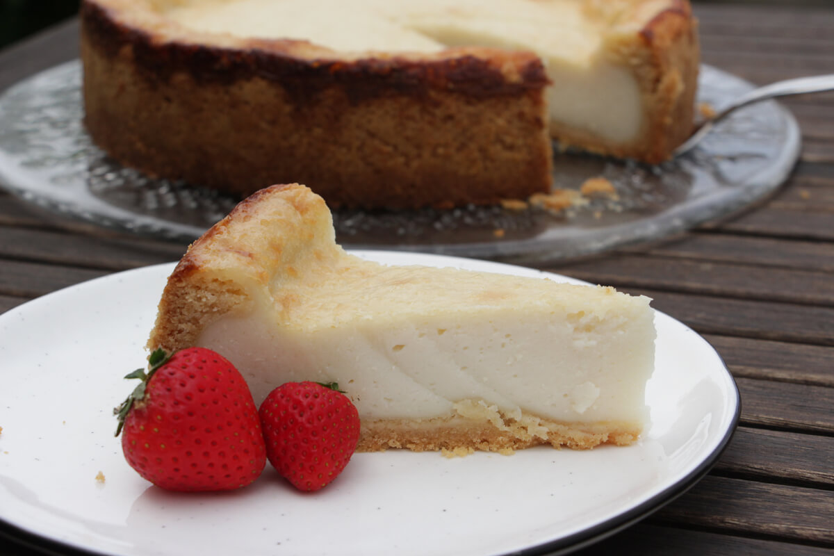 Ein Stück veganer Käsekuchen mit ein paar Deko-Erdbeeren