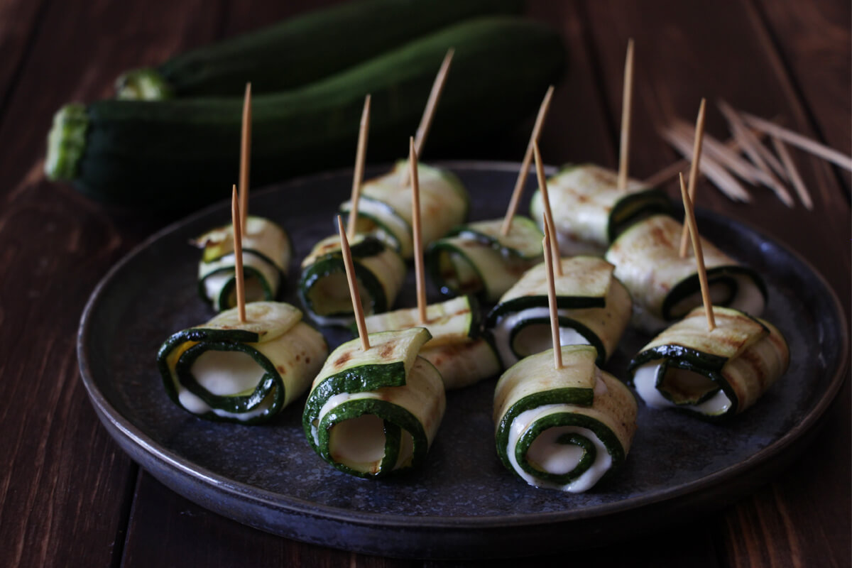 vegane Zucchiniröllchen mit Fetacreme auf einem Teller